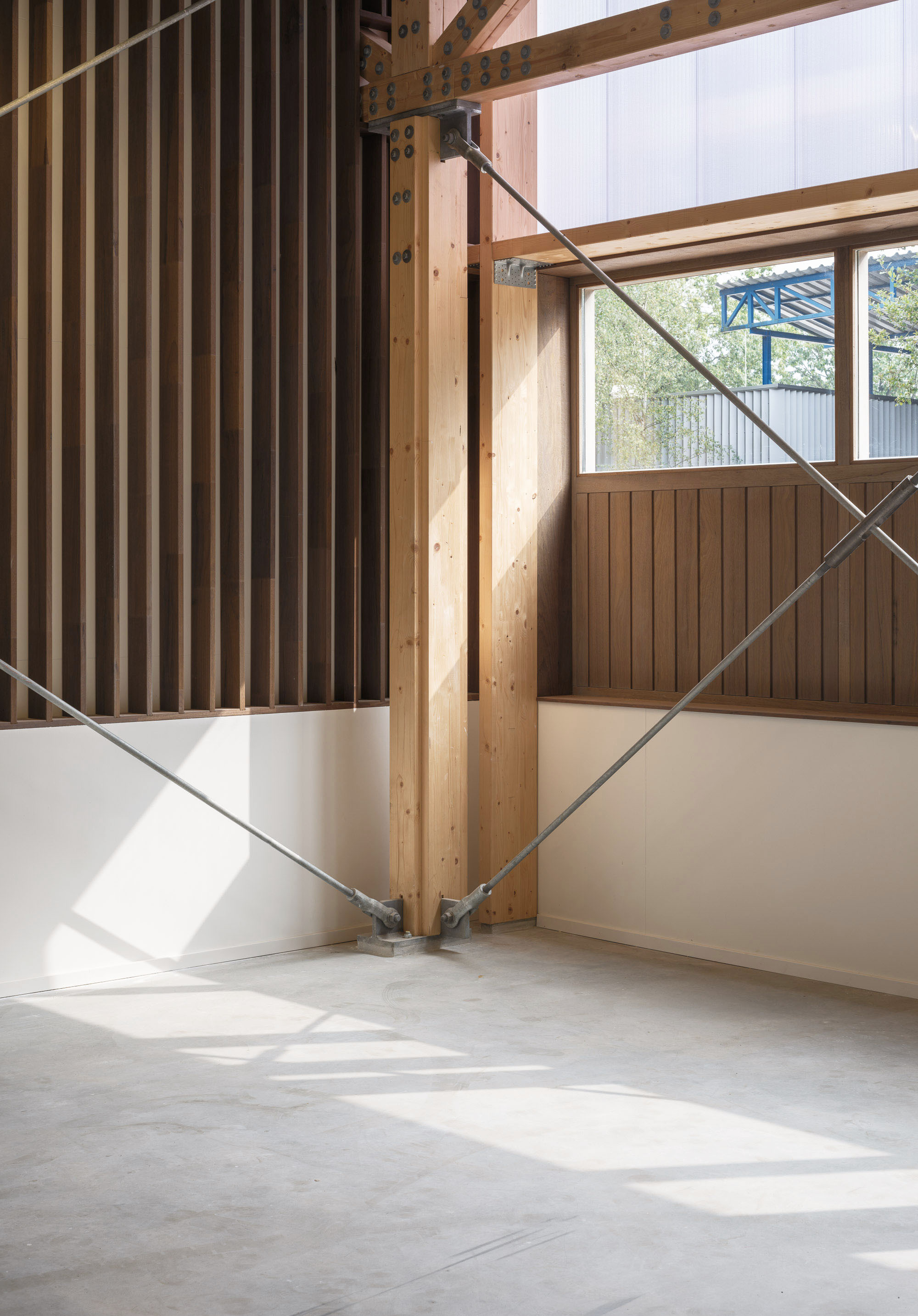 木構造 CLT 木樑柱與拉索結構形成穩定的力學支撐，金屬節點的細節設計強調工藝之美