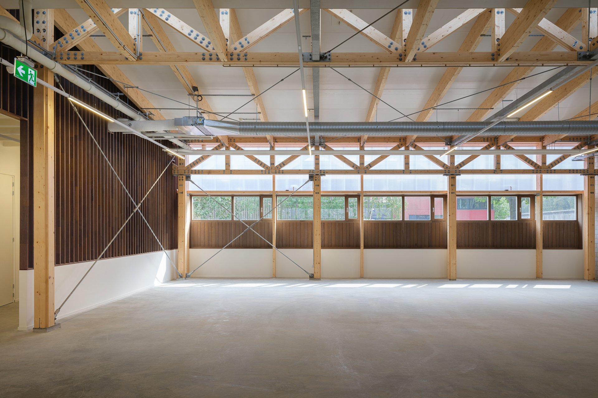 荷蘭監獄Penitentiary Warehouse 受刑人實習商店 木構造 CLT 屋頂桁架由木材支撐，配合通透PC牆面，讓室內充盈自然光