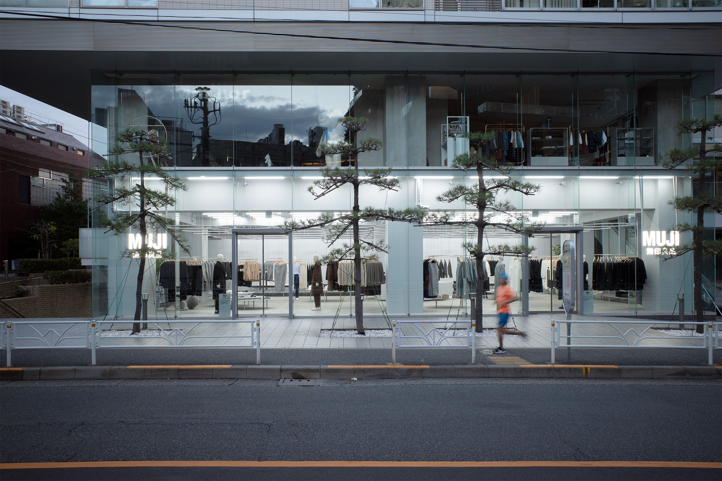 MUJI Labo 代官山店透過全景玻璃外牆營造通透感，讓行人能從街道清楚看到室內陳列。玻璃與金屬框架結構展現了輕盈與現代感