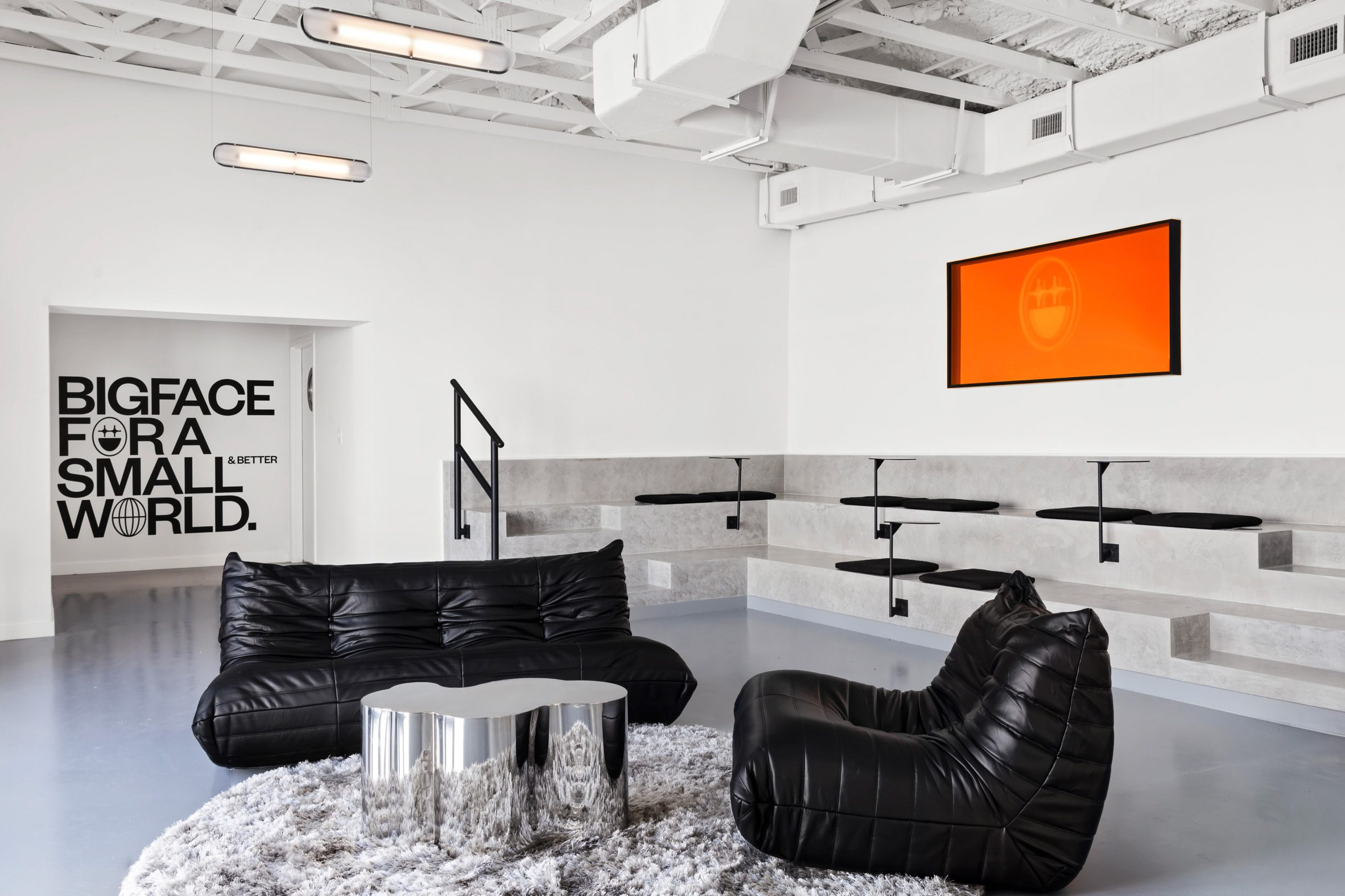 Bigface Coffee 邁阿密 室內設計 簡約未來感 黑色皮革沙發 Togo by Ligne Roset 階梯式座位區 灰色混凝土