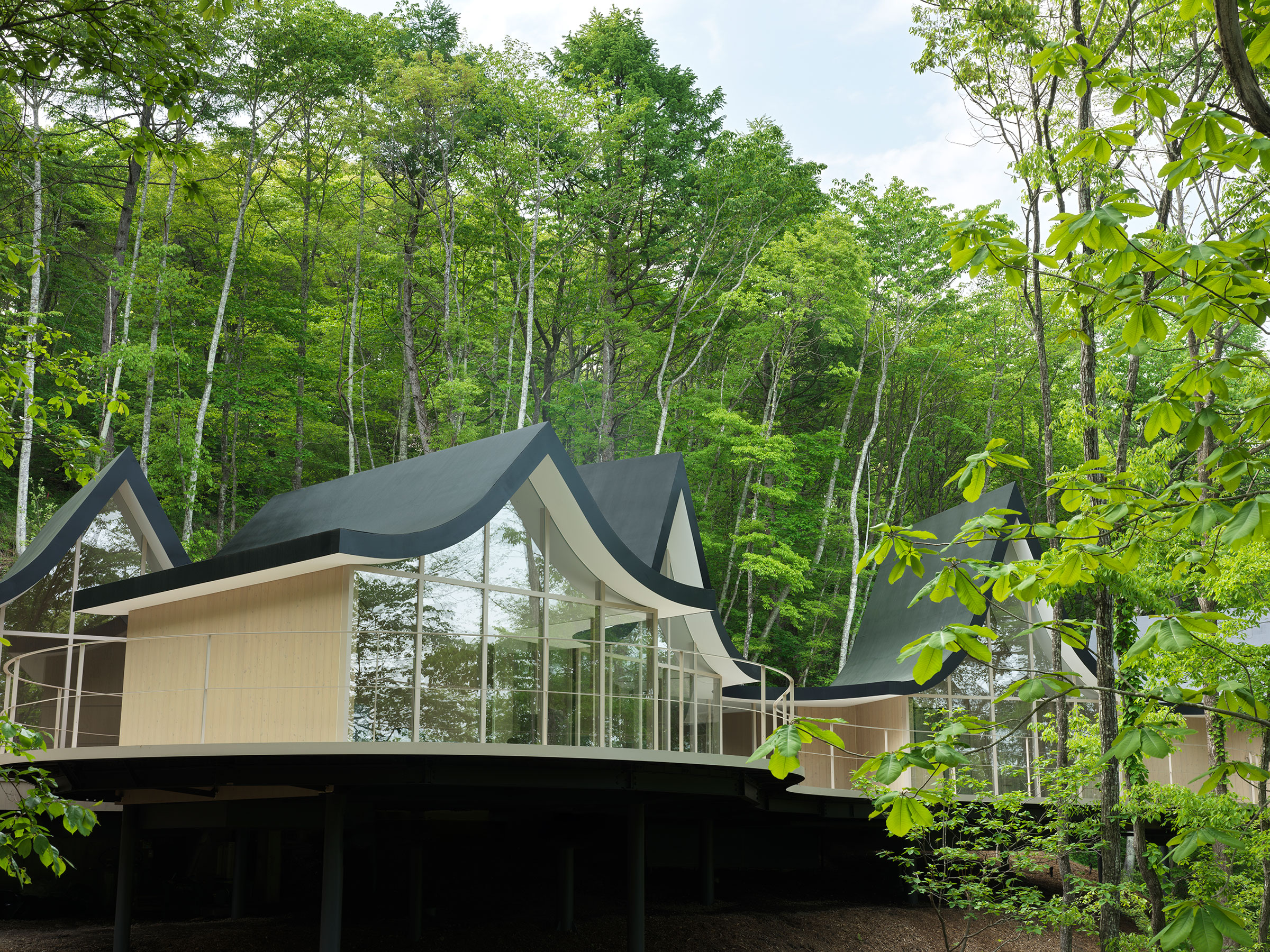 基地林木蓊鬱，並坐擁遠方淺間山的壯麗景色，為了使這棟別墅與周遭環境協調共存，Nendo 採取了化整為零的配置策略