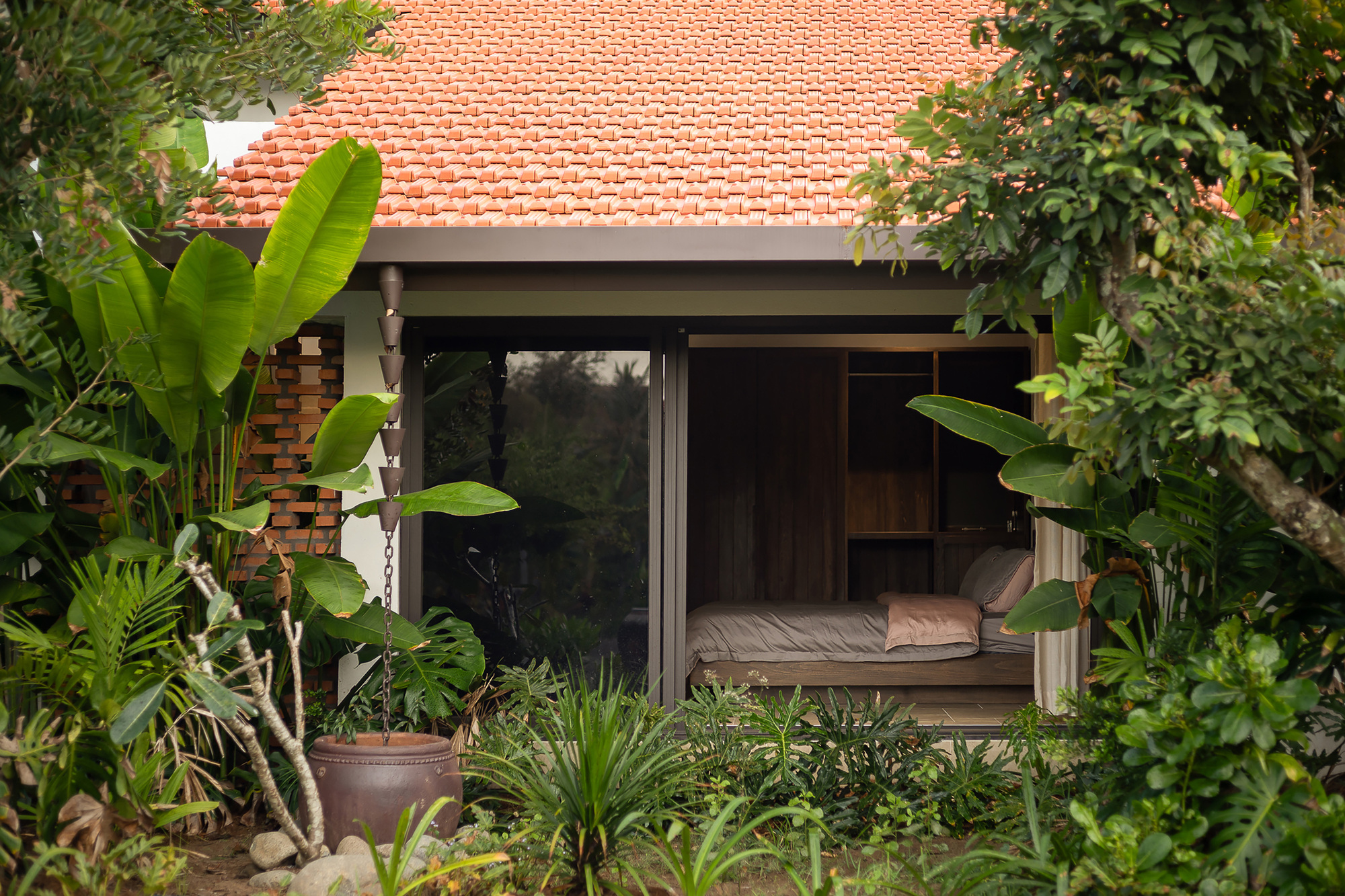 Casa Blanca Garden 越南私人住宅 以紅瓦屋頂與開放格局,勾勒出越南傳統與現代生活的交響曲。建築史學家指出,紅瓦源於19世紀法國殖民時期,後融入越南鄉村建築,成為地方符號