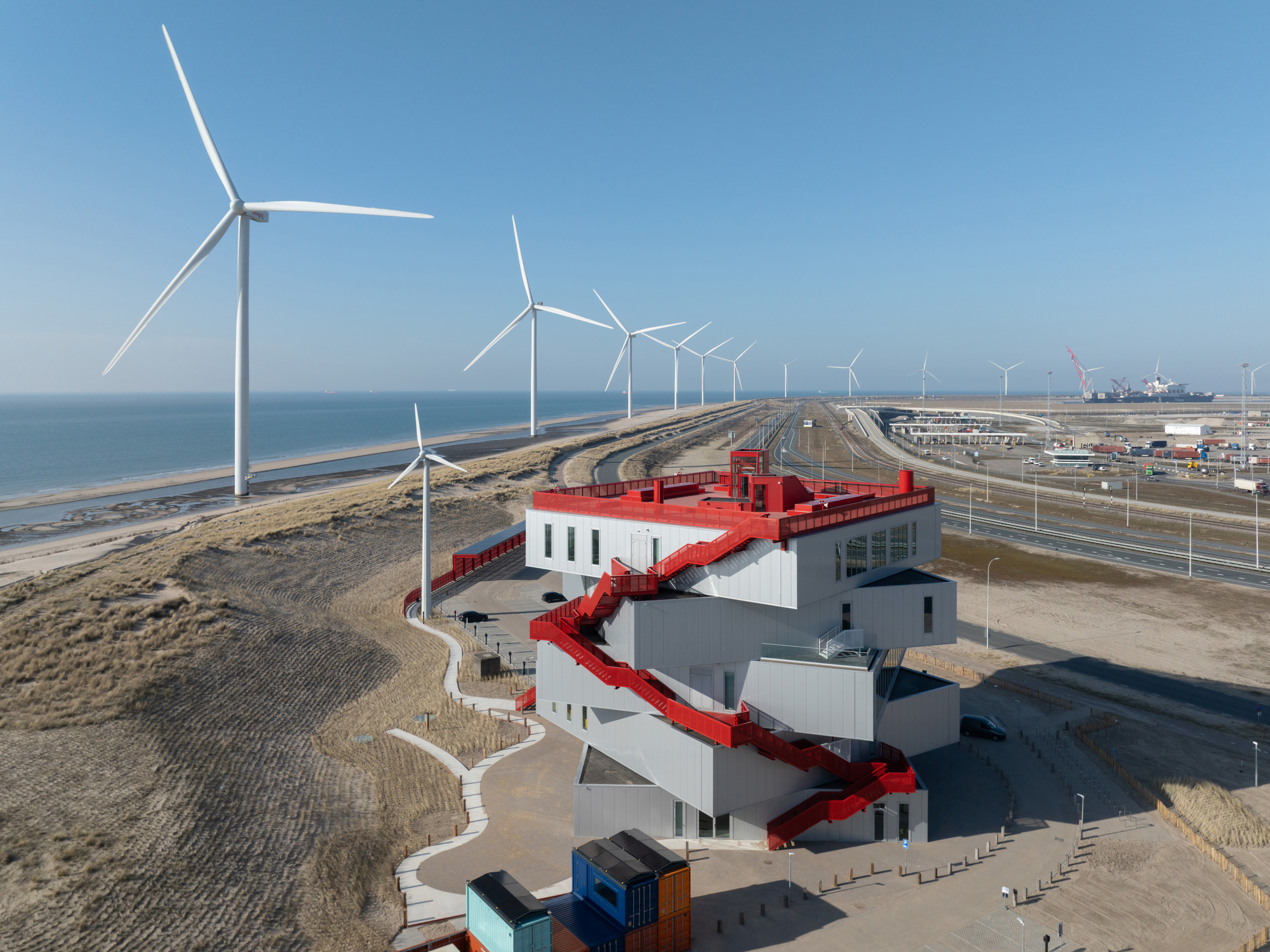 MVRDV Portlantis 建築由五個旋轉疊置的展覽空間所組成，其醒目的深紅色公共動線從沙丘一路延伸至屋頂，並在各個方向提供壯麗的景觀：北海、海岸線與港口一覽無遺
