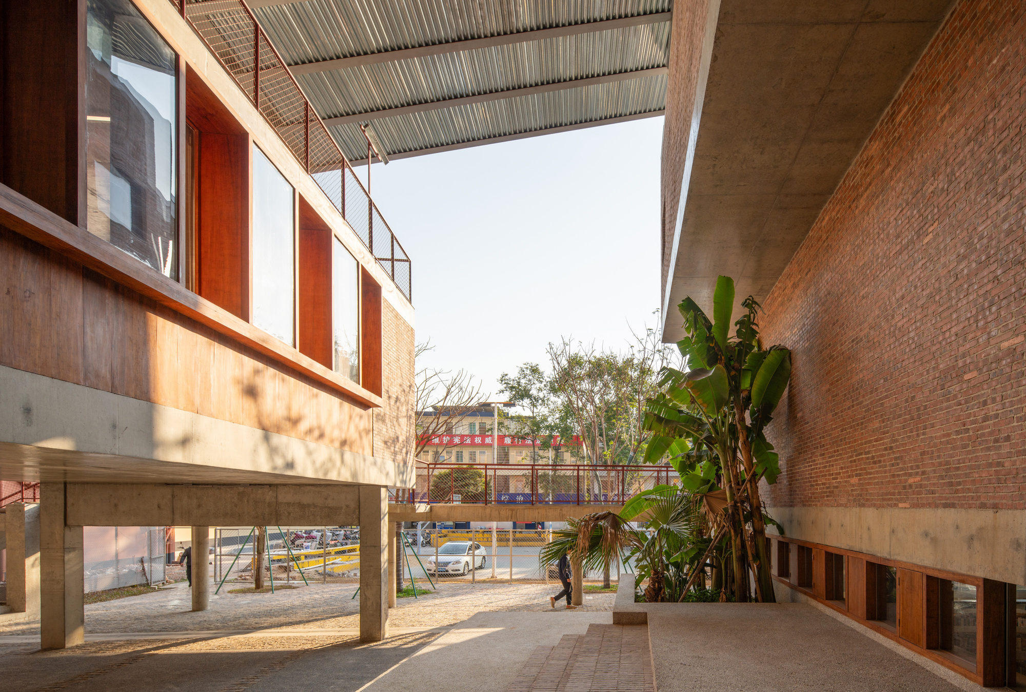 各個機能單元錯落有致地分佈在同一屋簷下，透過層高變化與半室外連廊有機串聯，使得穿堂而過的海風在簷下流轉，達到「開軒納微涼」的自然降溫效果