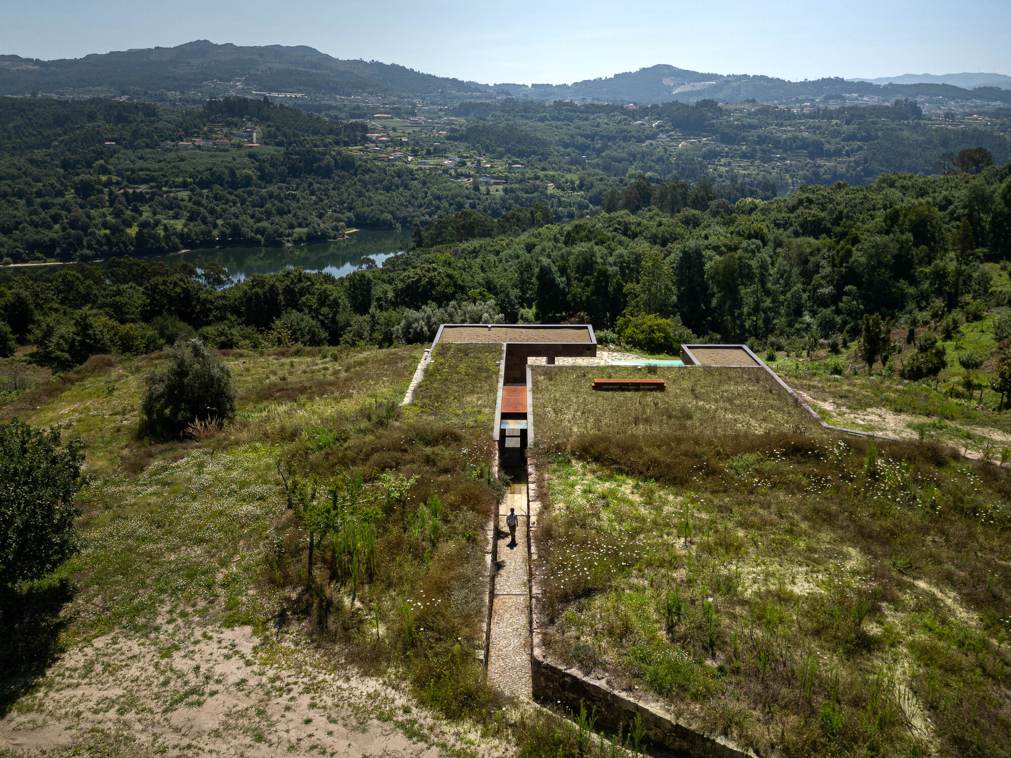由人行步道引領,Casa da Levada 的入口如同一條凹入綠地的痕跡,潛入住宅領域