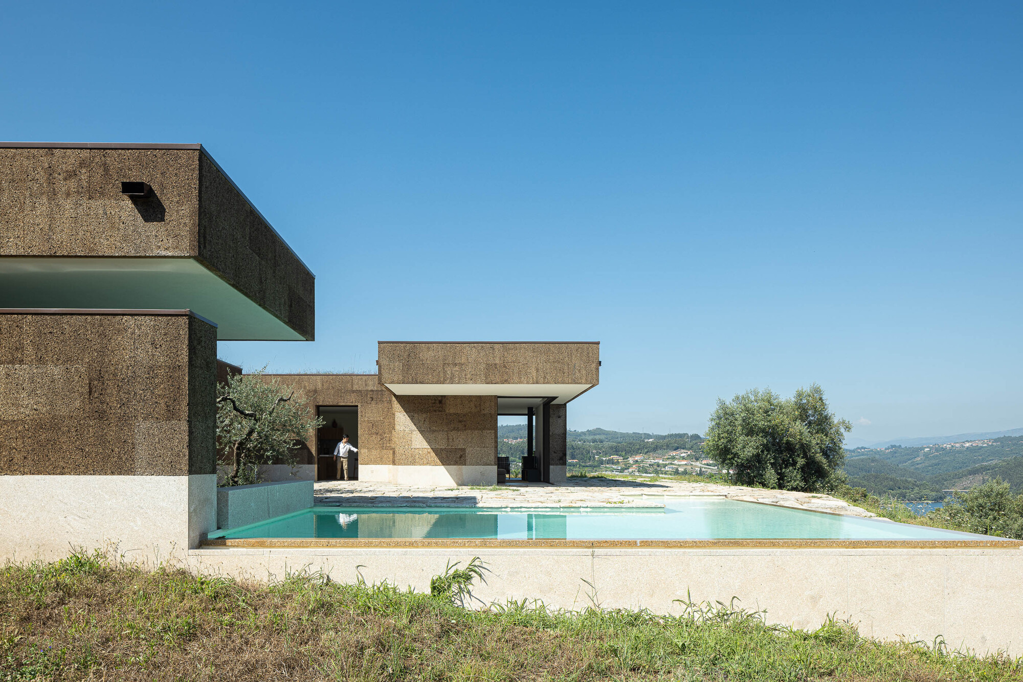 Tiago Tsou 葡萄牙私人住宅 Levada House Tsou Arquitectos  住宅外牆使用軟木板作為主要覆層，不僅具備天然隔熱效果，也呼應葡萄牙傳統建材語彙。屋頂則以景觀綠化延伸地形，使建築彷彿隱身於地貌之中