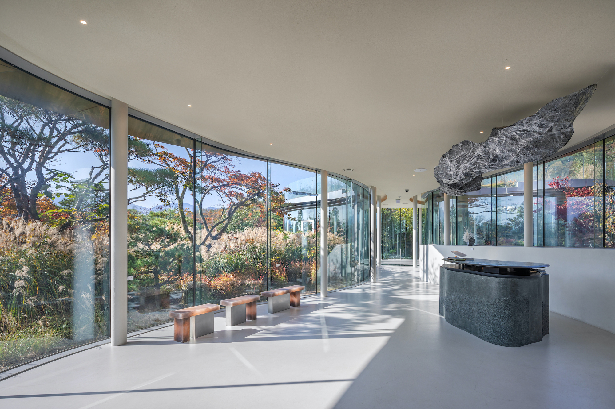 韓國複合文化空間蔚山市蔚州郡「MIGIUI」Architect-K 為實現建築「消失」於自然的構想，團隊大膽採用厚度僅28mm的弧形玻璃帷幕