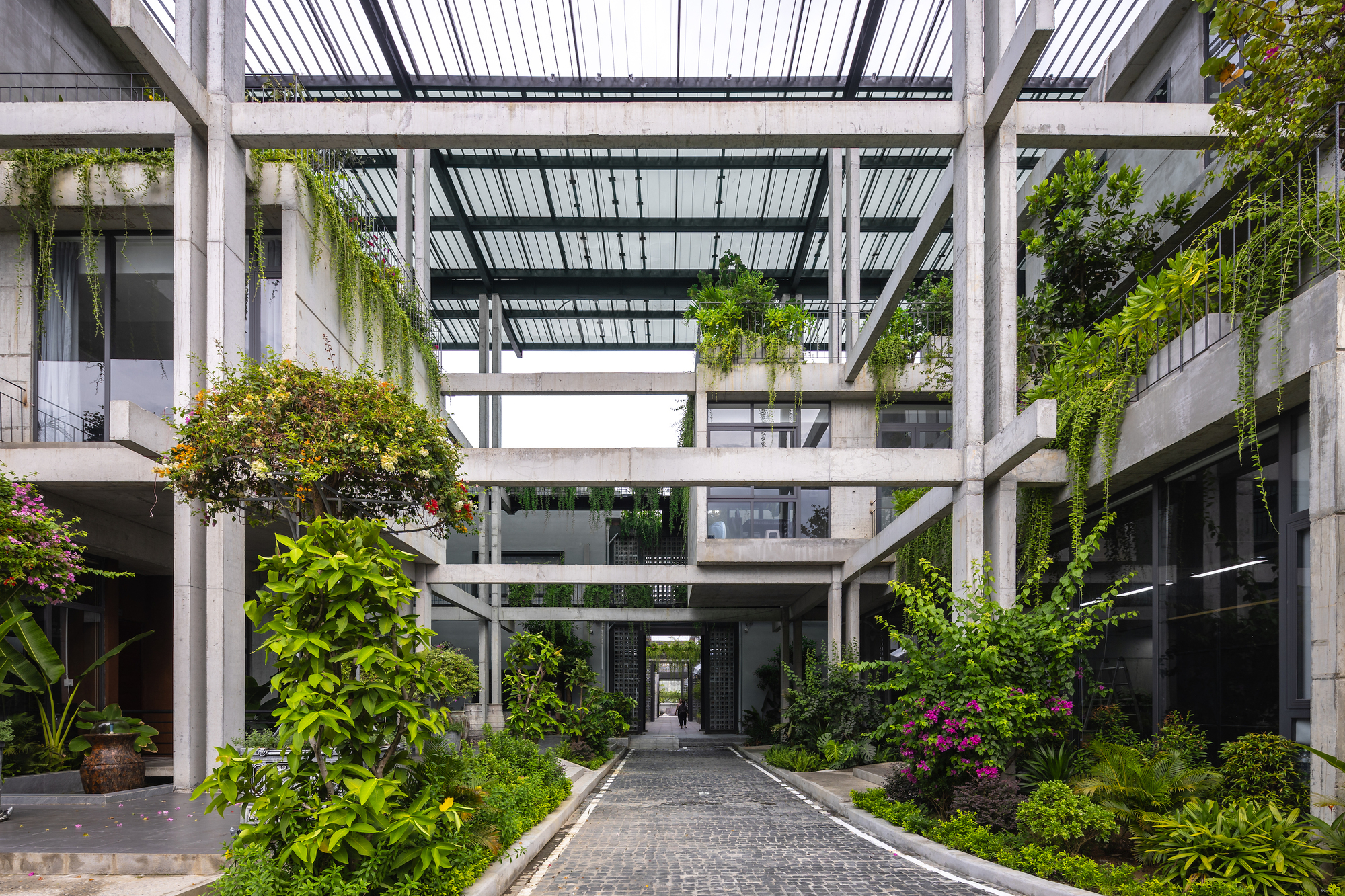 位於越南峴港工業核心的 Textile Factory Office 紡織公司廠辦大樓，越南建築師事務所 Ho Khue Architects 操刀，將傳統織布機框架語彙導入混凝土樑柱結構，並結合自然通風、綠植中庭與再生建材，使24小時運轉的工廠辦公空間在功能之外兼顧人體工學與精神舒適