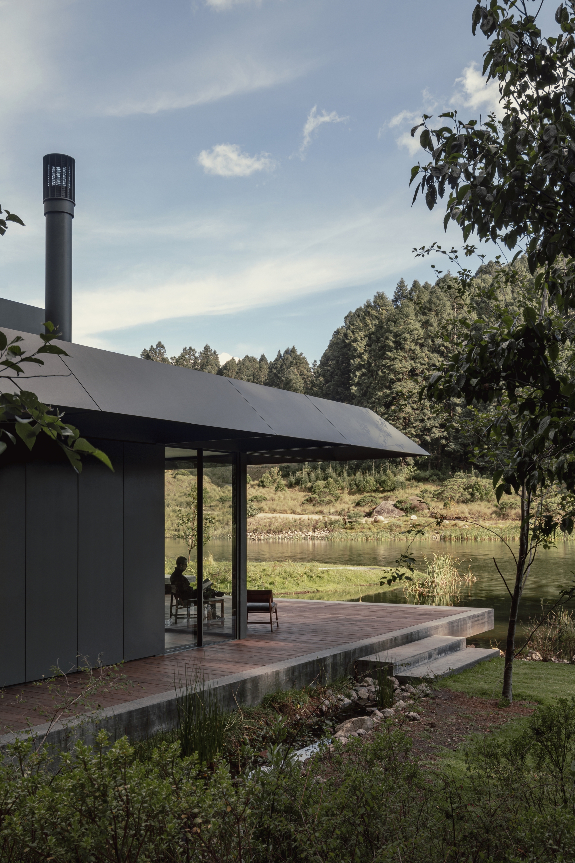 Pabellon de la Reserva（Pavilion of the Reserve）的建築框架呈現一種精巧細膩的質地，以沉穩的灰綠色調呈現的懸挑式屋簷，姿態優雅地消解了建築的實體邊界，彷彿為周遭的自然環境裱上含蓄的畫框