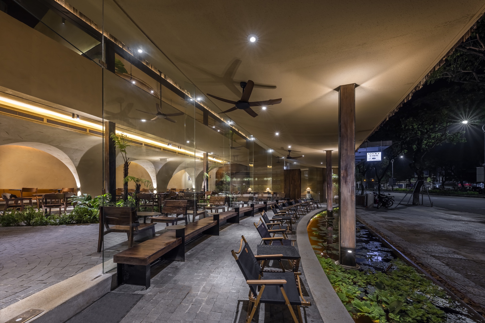 入口處靜水面標示出都市與內部靜謐之間的象徵邊界，其水面反光既是降溫手段，也讓進入空間的步伐自然緩慢