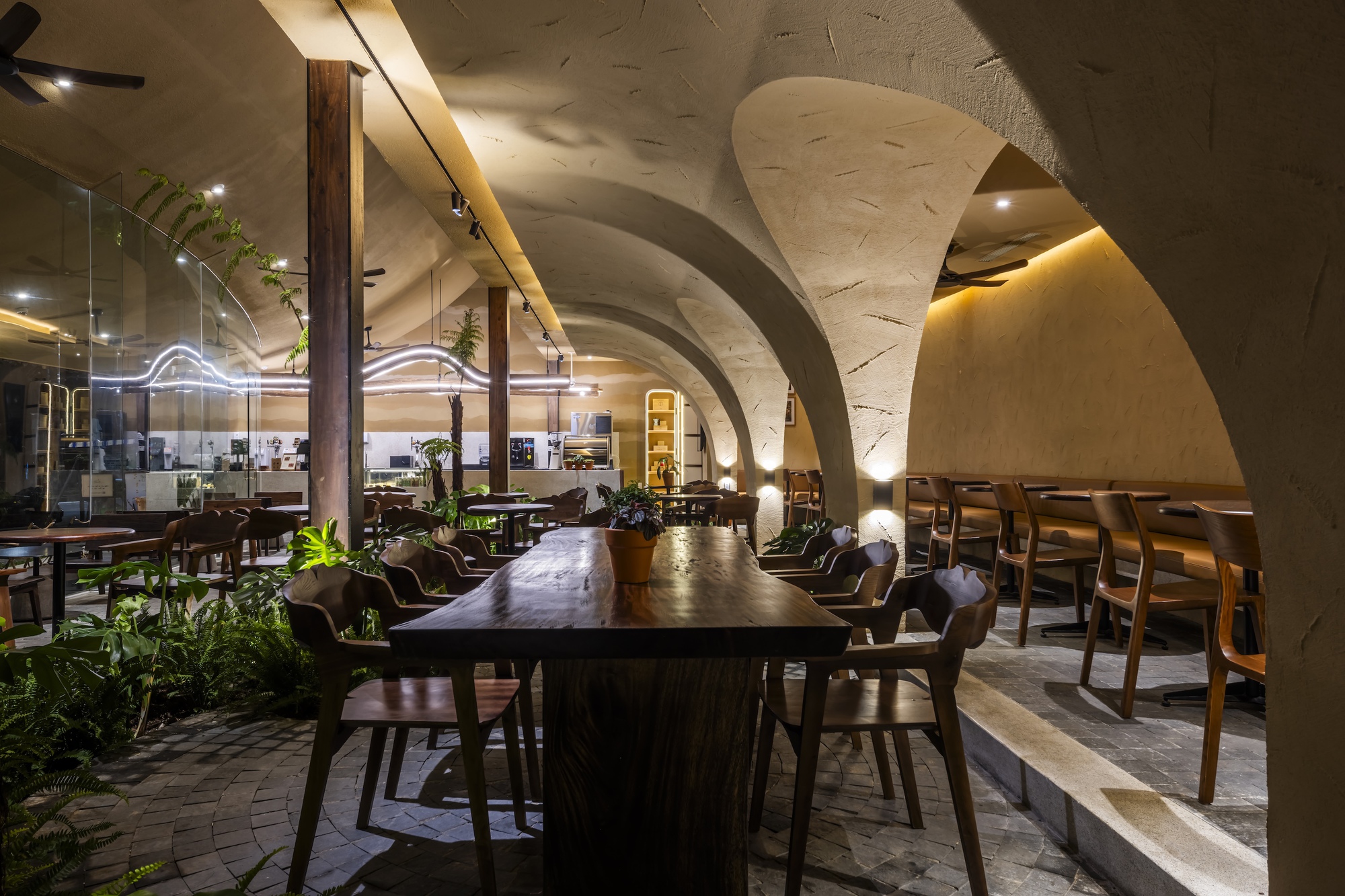 以連續曲面構築大範圍屋頂與挑空中庭，成為連接一樓私密角落與二樓開放空間的流動橋梁