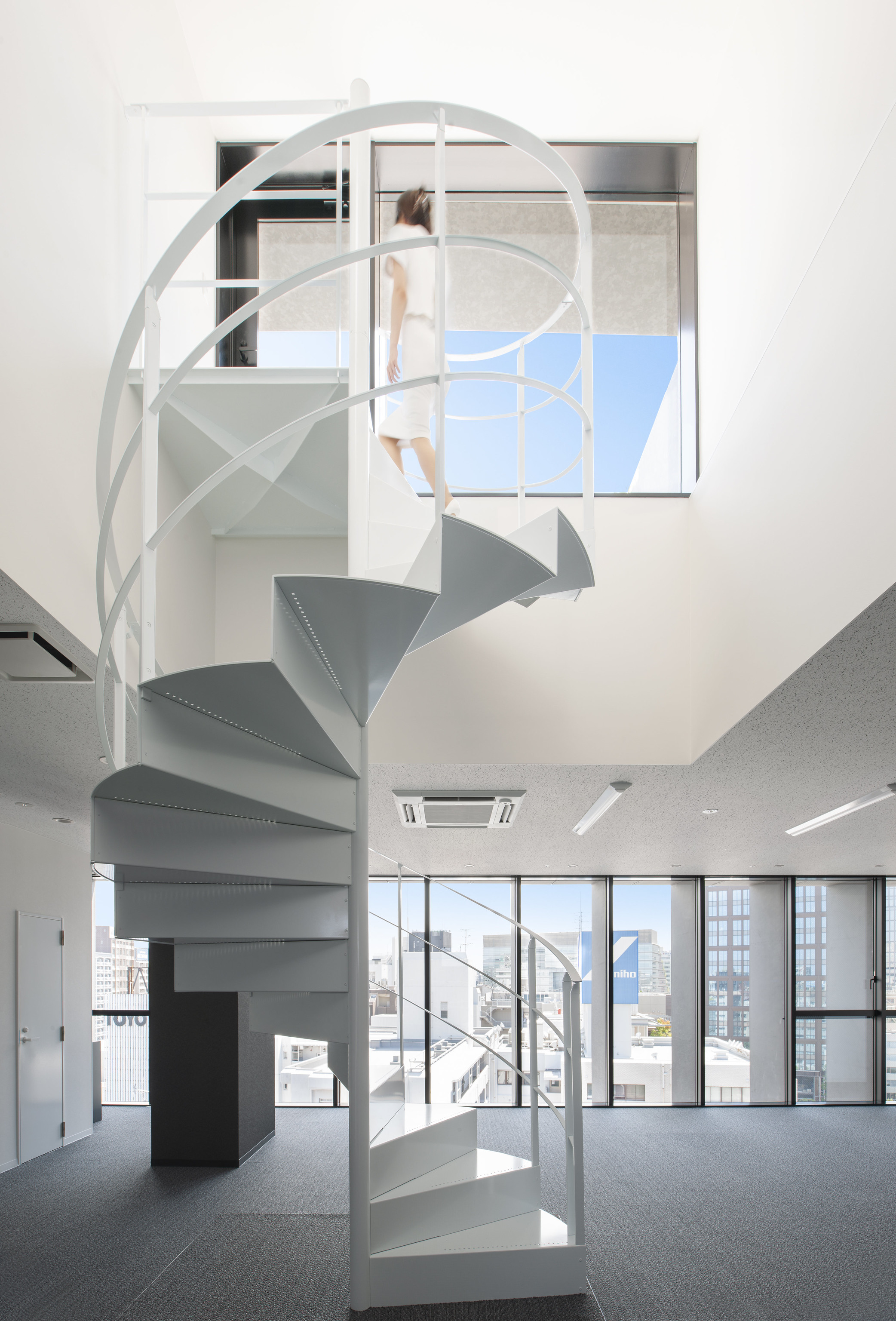 迫慶一郎 Keiichiro Sako SAKO建築設計工場 SAKO Architects 福岡 VECTORS in Fukuoka 辦公大樓 螺旋梯輕盈盤旋於雙層挑高的白色方盒中，對話著福岡市區的垂直節奏。金屬材質在自然光與格柵濾光下展現柔潤質地，串連樓層動線