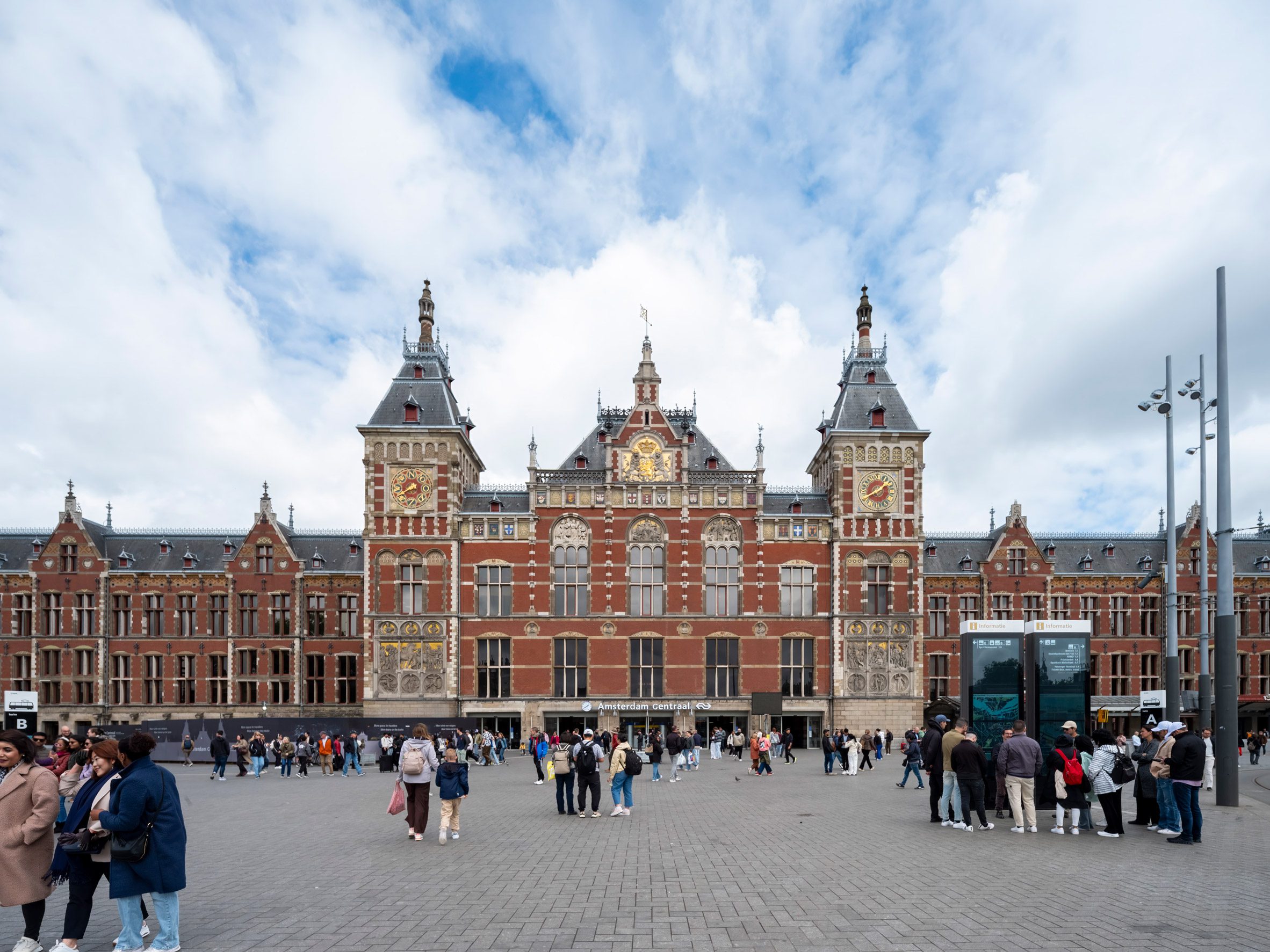 Amsterdam Centraal 阿姆斯特丹中央車站以紅磚與砂岩構築，展現 Pierre Cuypers 十九世紀歷史主義風格，如今在廣場前迎接進入英國航廈的當代旅人