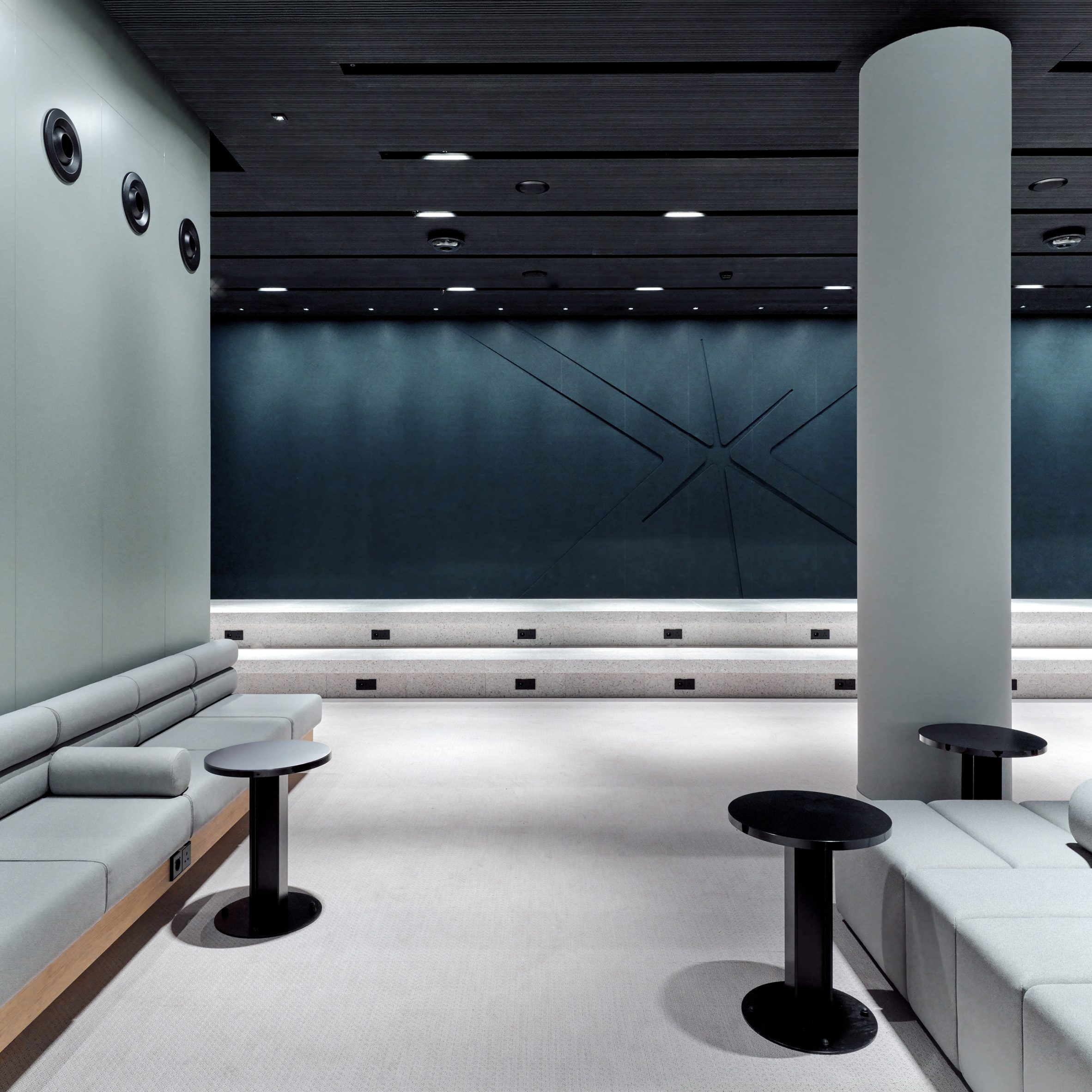 Superimpose Architecture 歐洲之星 Eurostar 候車室 阿姆斯特丹中央車站 Amsterdam Centraal 深藍牆面以幾何刻痕呼應歐洲之星標誌，搭配Lapalma小桌與模組沙發，塑造沉靜中具動勢的候車休憩區