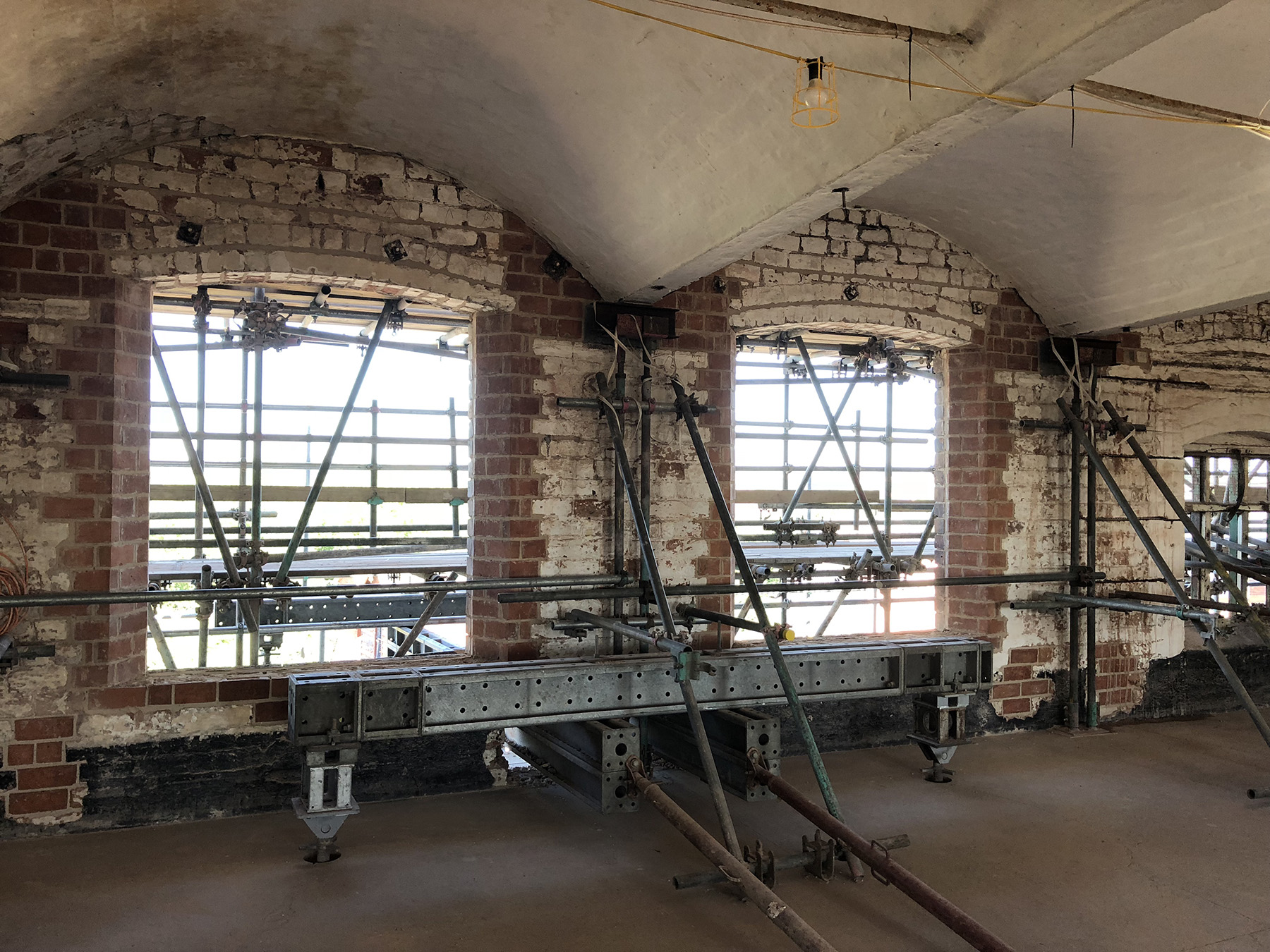 Various scaffolding schemes were adopted to allow work crews to repair the masonry walls and window openings. In this case, work crews threaded a masonry needle frame around the existing temporary propping scaffolding. (Photograph courtesy of AKT II)