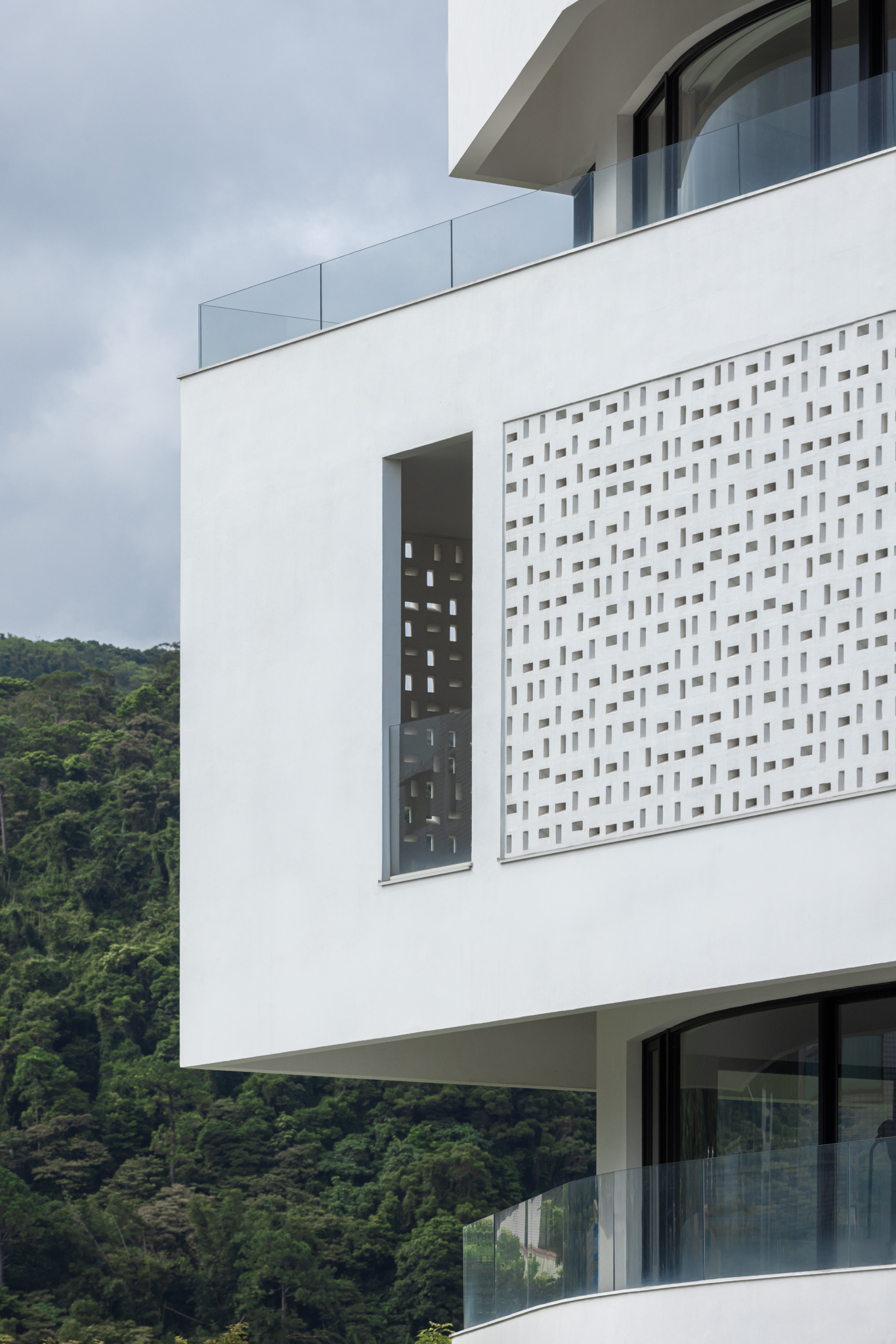 針對嚴峻的西曬，行一建築在立面設計了一道具備孔隙的花磚屏牆。這道雙層表皮不僅是高效的氣候調節器，阻絕熱能並引導通風；更是一層「光的畫布」